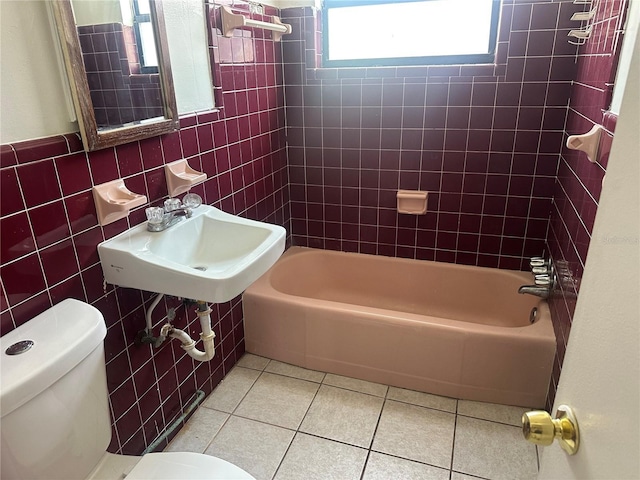708 N Johnson Ave, Arcadia, FL 34266 - bathroom with toilet, tile patterned floors, tile walls, a sink, and bathtub / shower combination