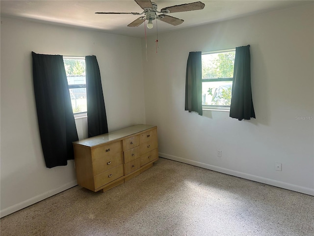 708 N Johnson Ave, Arcadia, FL 34266 - unfurnished bedroom featuring multiple windows, baseboards, and dark aggregate flooring