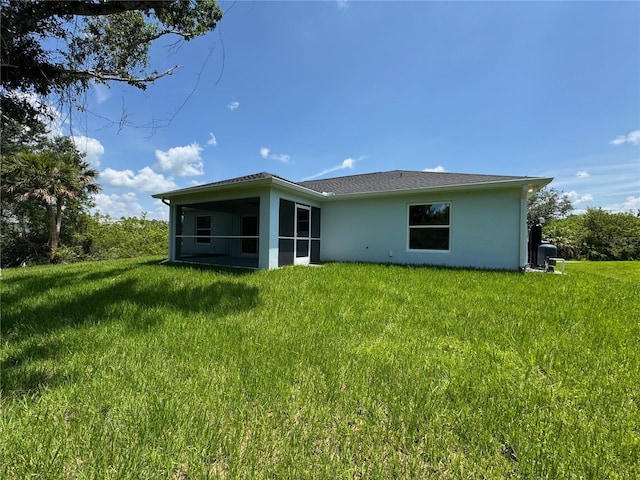 8667 Lisa Blvd, North Port, FL 34288 - back of house featuring stucco siding, a sunroom, and a yard