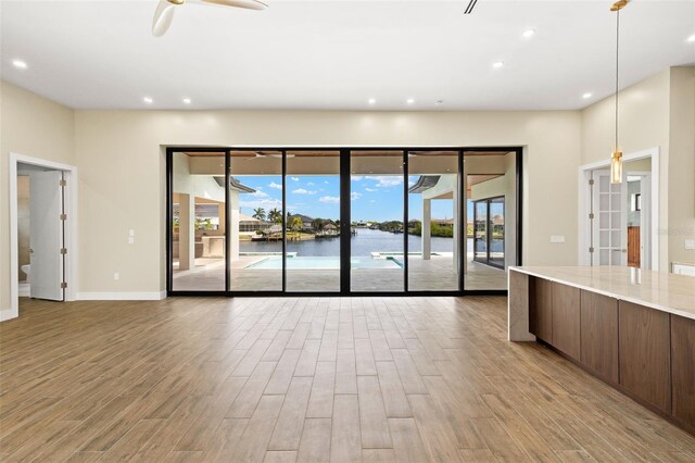 3413 NW 9th Ter, Cape Coral, FL 33904 - unfurnished living room featuring wood finished floors, plenty of natural light, and recessed lighting