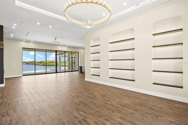 3413 NW 9th Ter, Cape Coral, FL 33904 - unfurnished living room featuring baseboards, recessed lighting, built in features, dark wood-type flooring, and a raised ceiling
