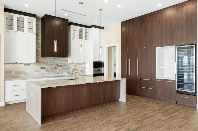 3413 NW 9th Ter, Cape Coral, FL 33904 - kitchen featuring beverage cooler, a sink, backsplash, light wood-style flooring, and recessed lighting
