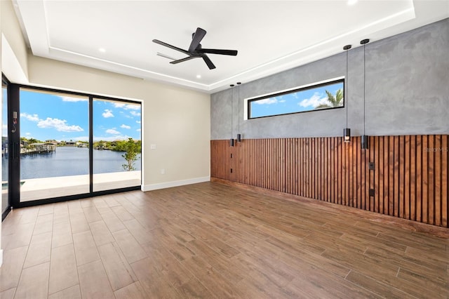 3413 NW 9th Ter, Cape Coral, FL 33904 - spare room with a raised ceiling, wood finished floors, ceiling fan, recessed lighting, and a water view