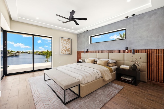 3413 NW 9th Ter, Cape Coral, FL 33904 - bedroom with a tray ceiling, access to outside, recessed lighting, a water view, and wood finished floors