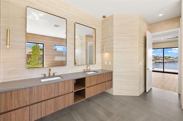 3413 NW 9th Ter, Cape Coral, FL 33904 - bathroom featuring double vanity, tile walls, tile patterned flooring, and a water view