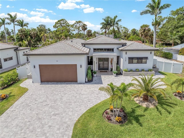 1324 Longwood Dr, Fort Myers, FL 33919 - view of front facade featuring french doors, a garage, decorative driveway, stucco siding, and a gate