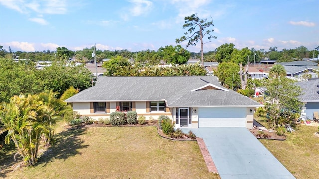 566 Reading St NW, Port Charlotte, FL 33952 - ranch-style home featuring an attached garage, concrete driveway, a front yard, and roof with shingles