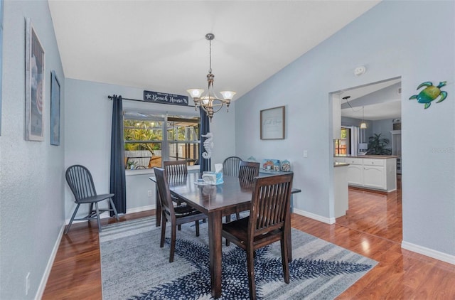 566 Reading St NW, Port Charlotte, FL 33952 - dining space with a chandelier, healthy amount of natural light, vaulted ceiling, and wood finished floors