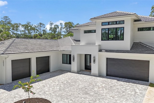 3632 Golden Gate Blvd W, Naples, FL 34102 - contemporary home featuring decorative driveway, stucco siding, a tiled roof, and a garage