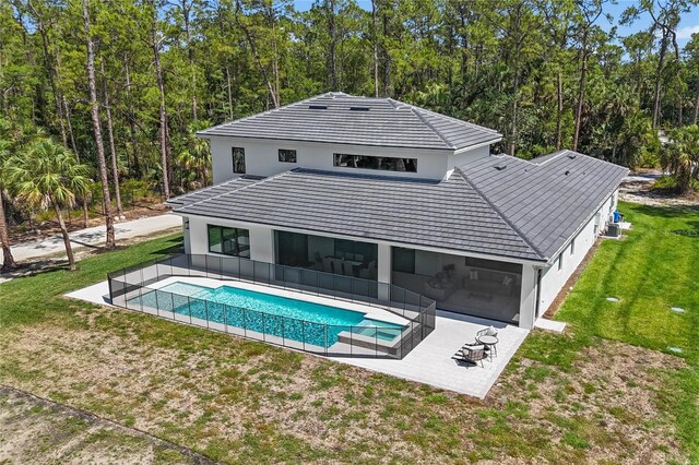 3632 Golden Gate Blvd W, Naples, FL 34102 - back of house featuring a patio area, a lawn, stucco siding, a sunroom, and a pool with connected hot tub