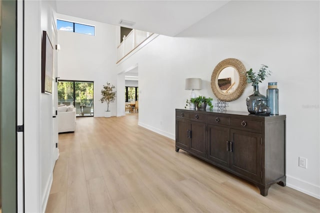 3632 Golden Gate Blvd W, Naples, FL 34102 - corridor featuring light wood-style flooring, plenty of natural light, baseboards, and a towering ceiling