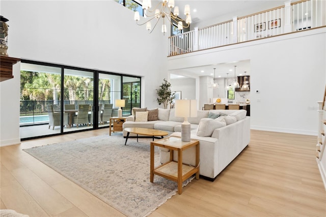 3632 Golden Gate Blvd W, Naples, FL 34102 - living room with light wood finished floors, baseboards, a towering ceiling, and a chandelier