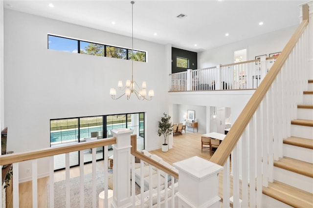 3632 Golden Gate Blvd W, Naples, FL 34102 - stairway featuring wood finished floors, a high ceiling, recessed lighting, and a chandelier