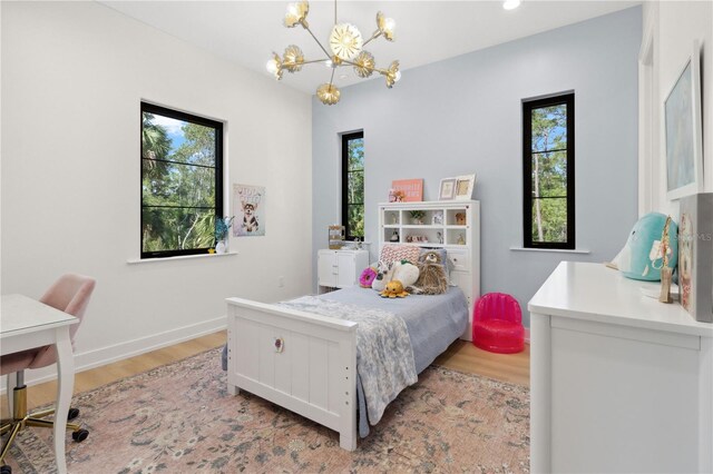 3632 Golden Gate Blvd W, Naples, FL 34102 - bedroom with a chandelier, light wood-style floors, and multiple windows