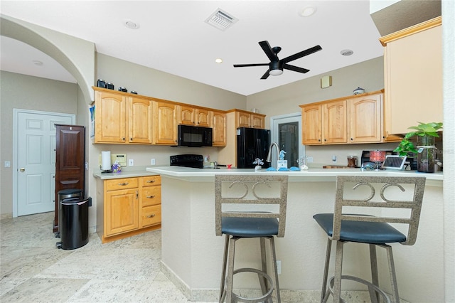 5219 Guava Ter, Port Charlotte, FL 33981 - kitchen featuring black appliances, ceiling fan, a kitchen breakfast bar, arched walkways, and a peninsula