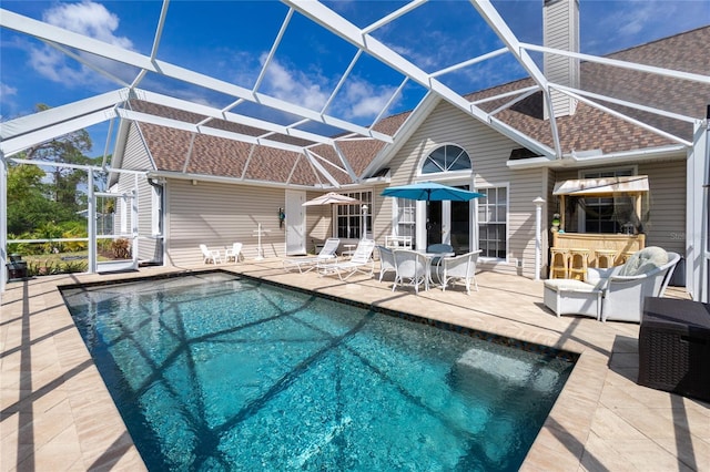 5219 Guava Ter, Port Charlotte, FL 33981 - back of house with a shingled roof, a patio area, a lanai, and an outdoor pool