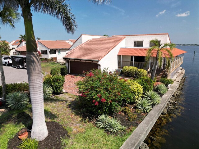 25188 Marion Ave Unit 1, Punta Gorda, FL 33950 - mediterranean / spanish-style home with a water view, a tile roof, stucco siding, a garage, and driveway