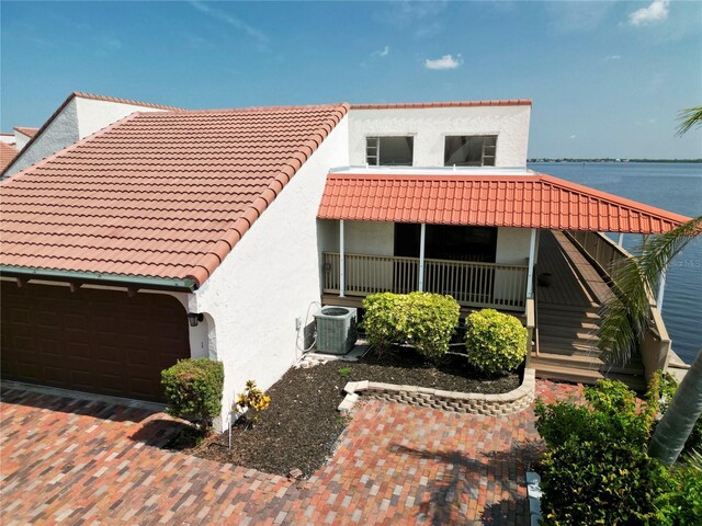 25188 Marion Ave Unit 1, Punta Gorda, FL 33950 - mediterranean / spanish-style home with a tiled roof, stucco siding, central AC unit, stairway, and a porch