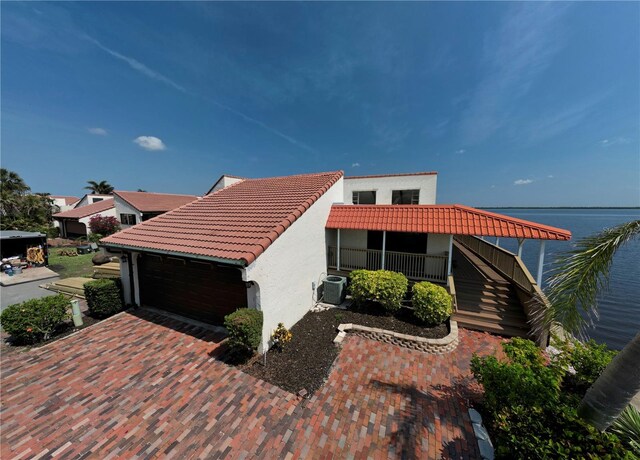 25188 Marion Ave Unit 1, Punta Gorda, FL 33950 - view of property exterior with a tile roof, stucco siding, central air condition unit, and a water view