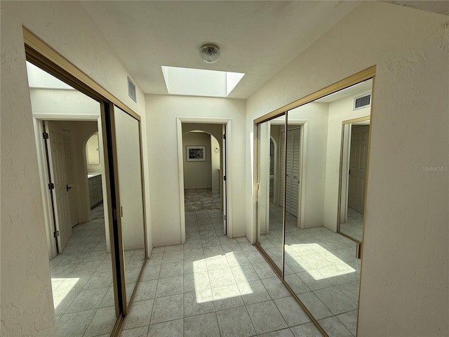 25188 Marion Ave Unit 1, Punta Gorda, FL 33950 - hallway featuring arched walkways, a skylight, and a textured wall