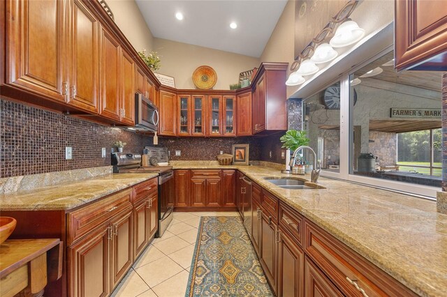 5600 Blackjack Ct S, Punta Gorda, FL 33982 - kitchen with appliances with stainless steel finishes, a sink, light tile patterned flooring, decorative backsplash, and light stone counters