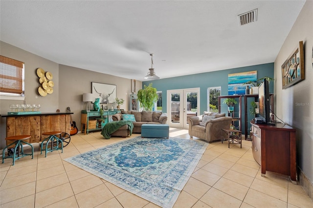 5600 Blackjack Ct S, Punta Gorda, FL 33982 - living room featuring light tile patterned floors, french doors, and a bar