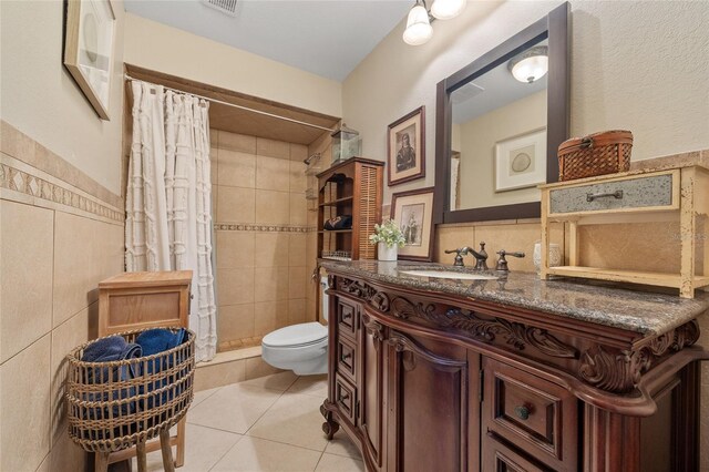 5600 Blackjack Ct S, Punta Gorda, FL 33982 - bathroom featuring tile walls, toilet, vanity, a shower stall, and tile patterned flooring