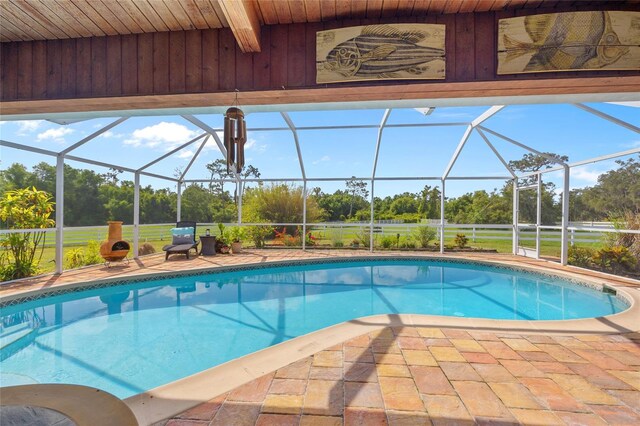 5600 Blackjack Ct S, Punta Gorda, FL 33982 - outdoor pool featuring a patio, glass enclosure, and view of wooded area