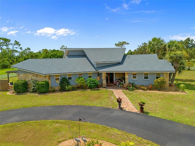 5600 Blackjack Ct S, Punta Gorda, FL 33982 - view of front of property featuring stone siding, a front lawn, and roof with shingles