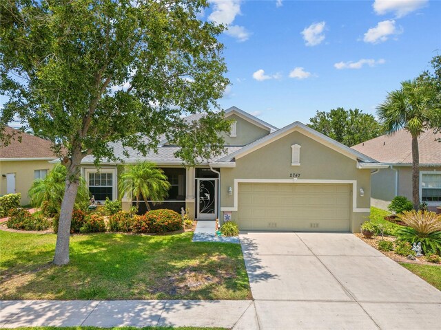 2747 Suncoast Lakes Blvd, Punta Gorda, FL 33980 - view of front of home with stucco siding, a garage, a front lawn, and concrete driveway
