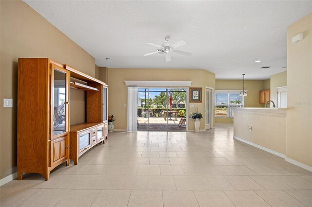 2747 Suncoast Lakes Blvd, Punta Gorda, FL 33980 - unfurnished living room with baseboards, a ceiling fan, and light tile patterned floors