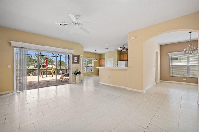2747 Suncoast Lakes Blvd, Punta Gorda, FL 33980 - unfurnished living room with a ceiling fan, arched walkways, baseboards, and a chandelier