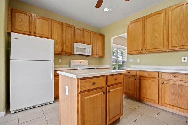 2747 Suncoast Lakes Blvd, Punta Gorda, FL 33980 - kitchen with white appliances, light tile patterned flooring, a center island, light countertops, and a ceiling fan