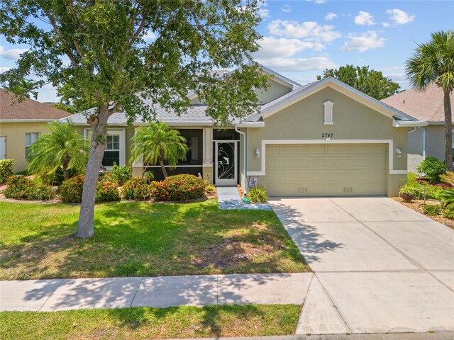2747 Suncoast Lakes Blvd, Punta Gorda, FL 33980 - view of front of home featuring an attached garage, a front lawn, stucco siding, and concrete driveway