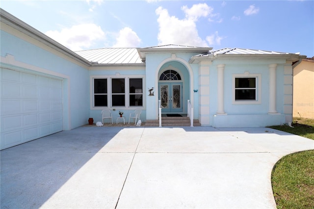 3772 Peace River Dr, Punta Gorda, FL 33983 - view of front of home with a standing seam roof, french doors, driveway, metal roof, and an attached garage