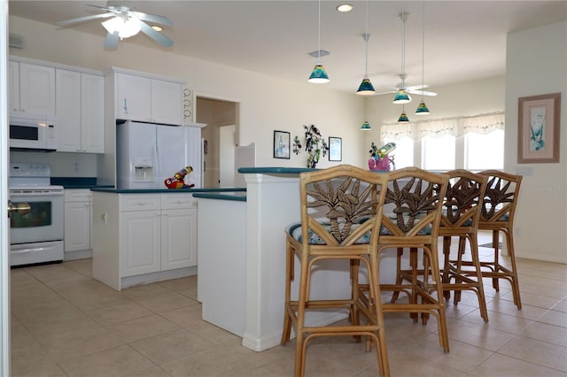 3772 Peace River Dr, Punta Gorda, FL 33983 - kitchen featuring white appliances, a ceiling fan, a center island, and light tile patterned flooring