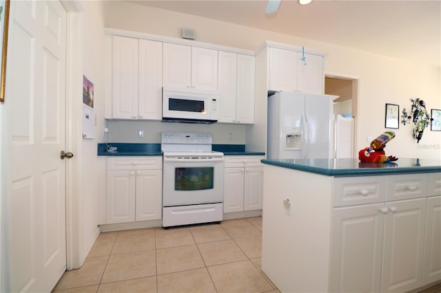 3772 Peace River Dr, Punta Gorda, FL 33983 - kitchen with white appliances, dark countertops, white cabinets, and light tile patterned floors