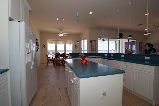 3772 Peace River Dr, Punta Gorda, FL 33983 - kitchen with white appliances, a center island, light tile patterned floors, a sink, and dark countertops