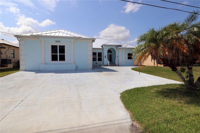3772 Peace River Dr, Punta Gorda, FL 33983 - view of front facade with a standing seam roof, a front lawn, metal roof, driveway, and stucco siding