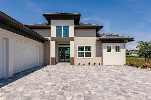 5061 Collingswood Blvd, Port Charlotte, FL 33948 - view of front of property featuring decorative driveway, concrete block siding, an attached garage, a tiled roof, and french doors
