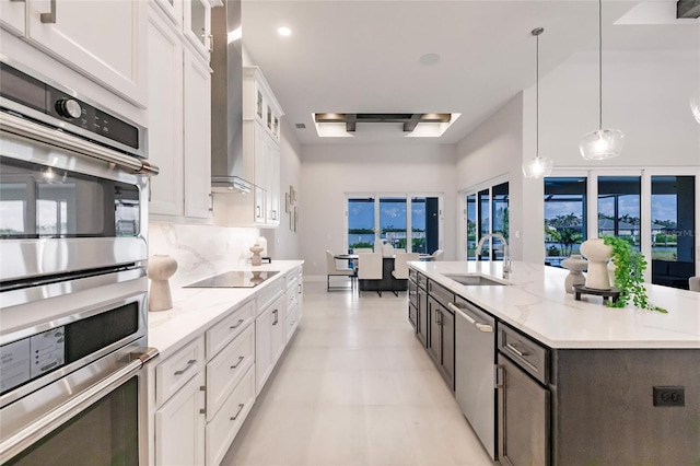 5061 Collingswood Blvd, Port Charlotte, FL 33948 - kitchen featuring stainless steel appliances, a sink, white cabinetry, a center island with sink, and wall chimney exhaust hood