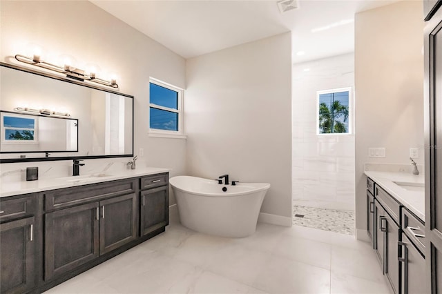 5061 Collingswood Blvd, Port Charlotte, FL 33948 - bathroom with two vanities, a walk in shower, a freestanding tub, and baseboards