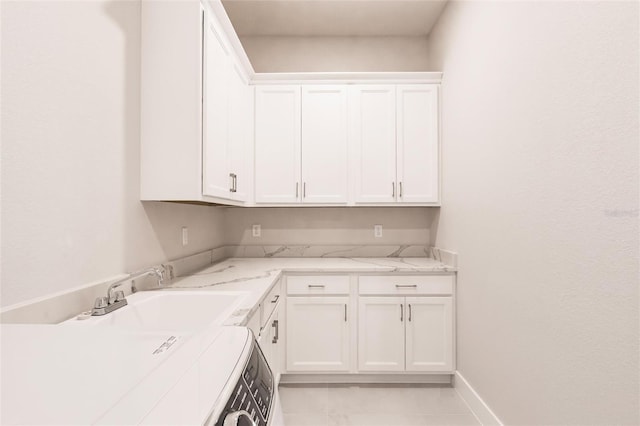 5061 Collingswood Blvd, Port Charlotte, FL 33948 - washroom featuring washer / clothes dryer, cabinet space, baseboards, and light tile patterned floors