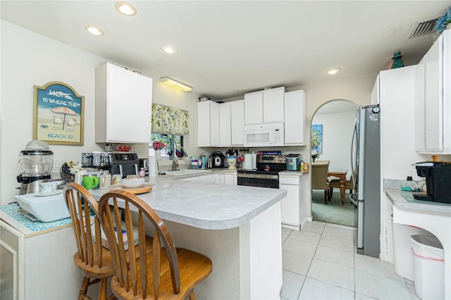6103 Fabian Rd, North Port, FL 34287 - kitchen featuring appliances with stainless steel finishes, a peninsula, light countertops, a kitchen bar, and a sink