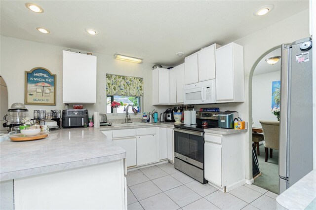 6103 Fabian Rd, North Port, FL 34287 - kitchen featuring appliances with stainless steel finishes, a sink, light countertops, a peninsula, and white cabinetry