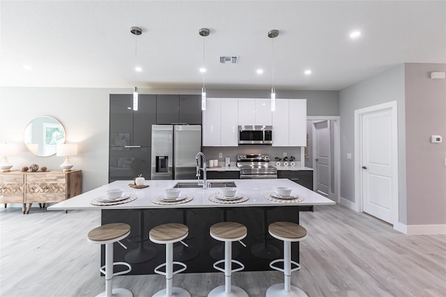 14350 Marlin Ave, Port Charlotte, FL 33953 - kitchen featuring appliances with stainless steel finishes, a sink, light wood finished floors, a center island with sink, and recessed lighting