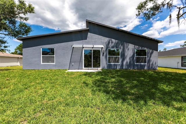 14350 Marlin Ave, Port Charlotte, FL 33953 - rear view of house featuring a lawn and stucco siding