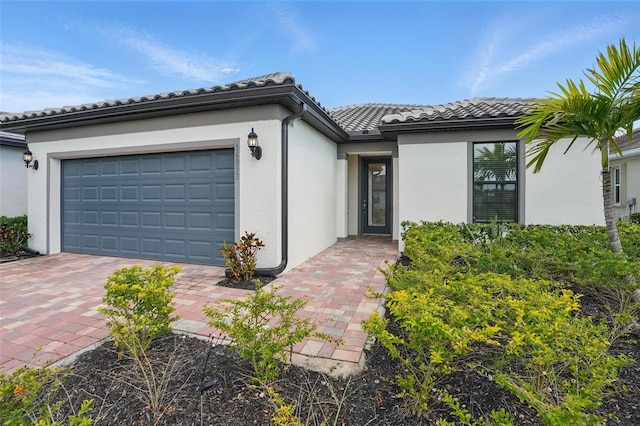 16053 Rosemallow Ln, Alva, FL 33920 - view of front facade featuring stucco siding, a tiled roof, decorative driveway, and an attached garage
