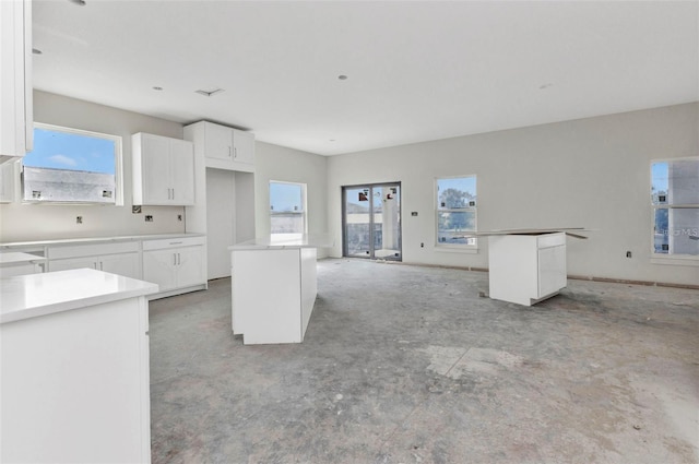 12299 Albrecht Ter, Port Charlotte, FL 33981 - kitchen featuring a center island, concrete floors, white cabinets, and open floor plan