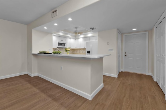 601 Shreve St Unit 64C, Punta Gorda, FL 33950 - kitchen with white appliances, recessed lighting, light wood-style floors, baseboards, and a peninsula